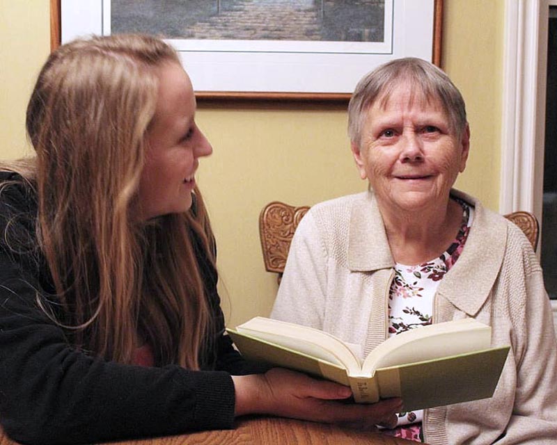 Rachel Thompson reads a book to her grandmother.